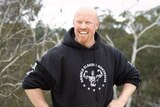 A bald man with a ginger beard in a hoodie.