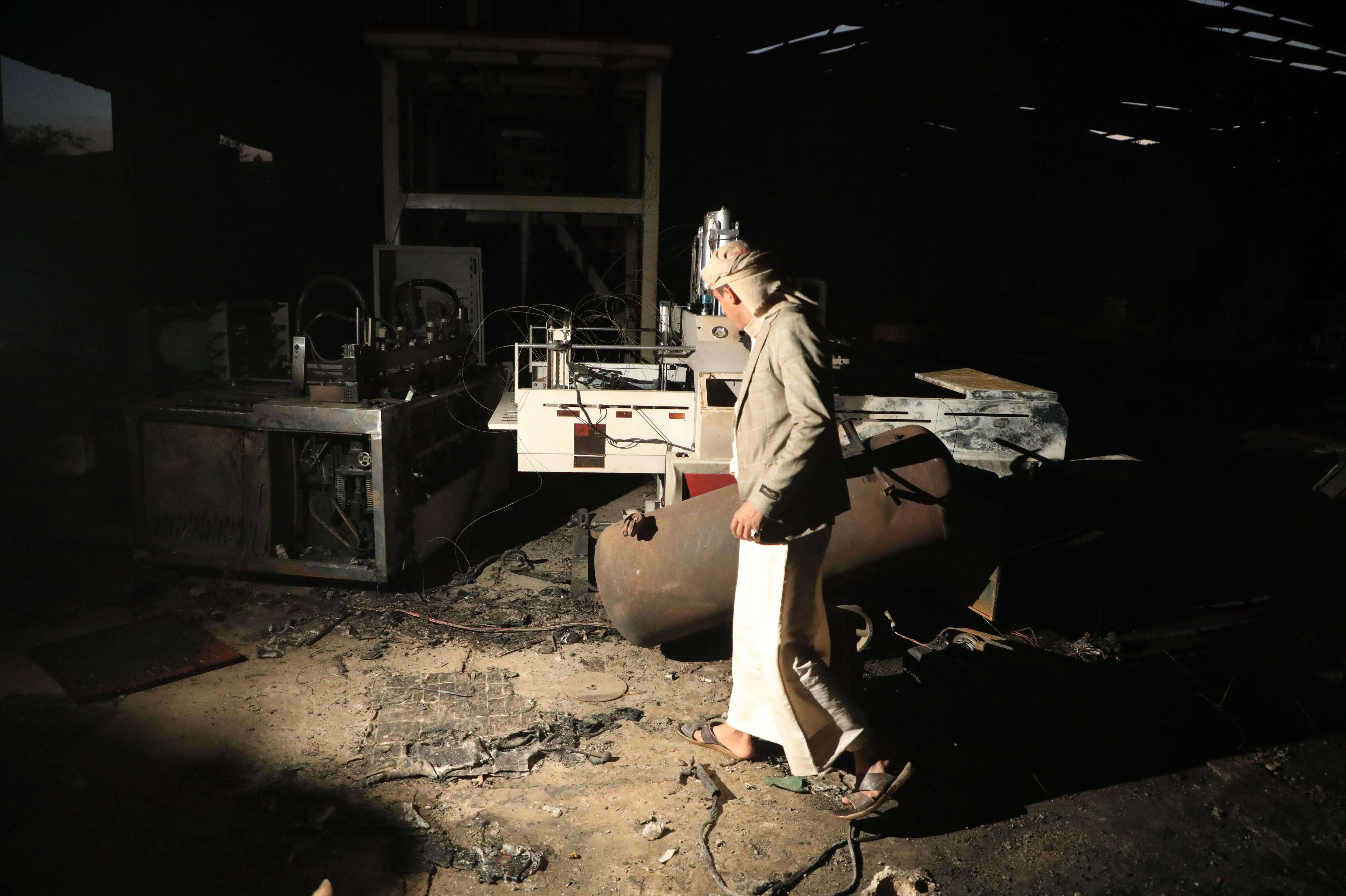 A man walks through a dusty shed at night.