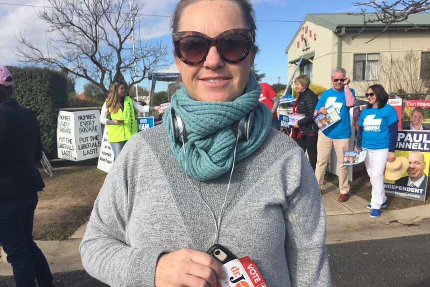 A woman wearing sunglasses and headphones at the Wagga Wagga by-election.