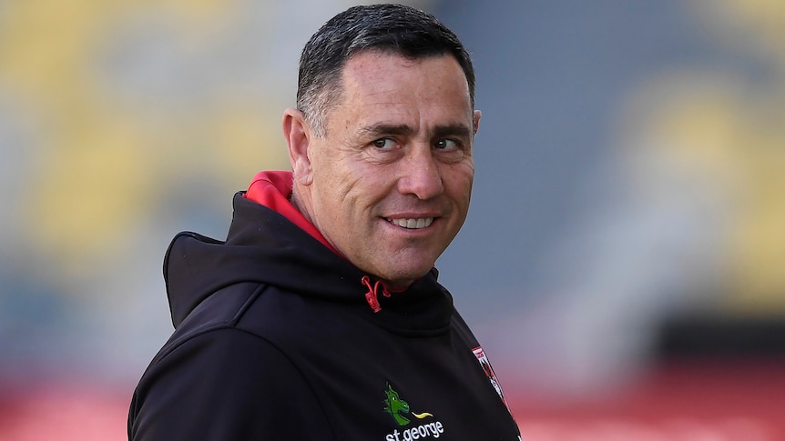A man grins while coaching a rugby league team