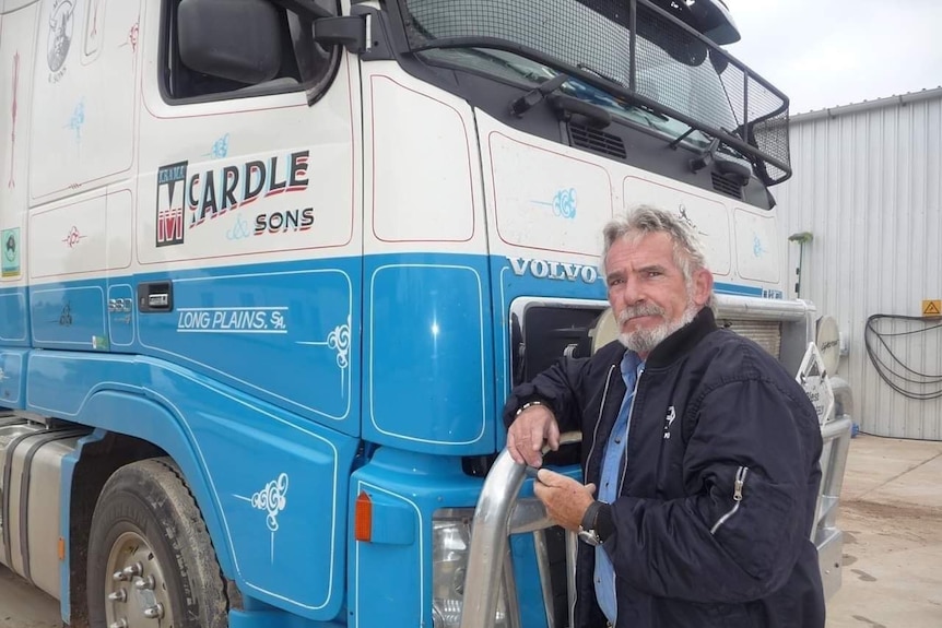 A man in front of a truck cab