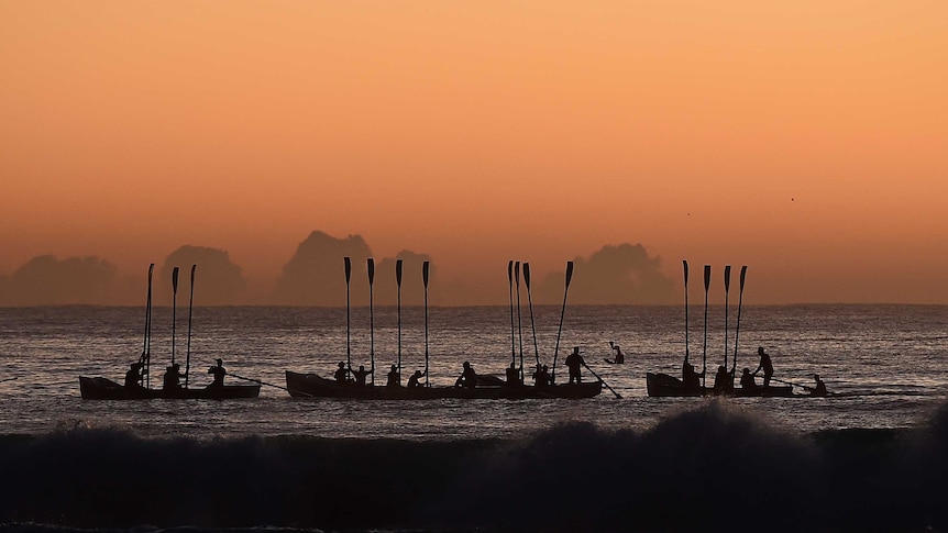 Surf boats perform a sea burial during the Anzac Day dawn service at Currumbin Surf Life Saving Club on the Gold Coast on Saturday, April 25, 2015.