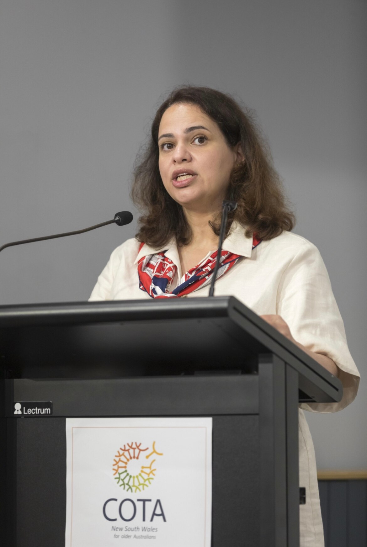 Gohar Yazdabadi  speaking into a microphone