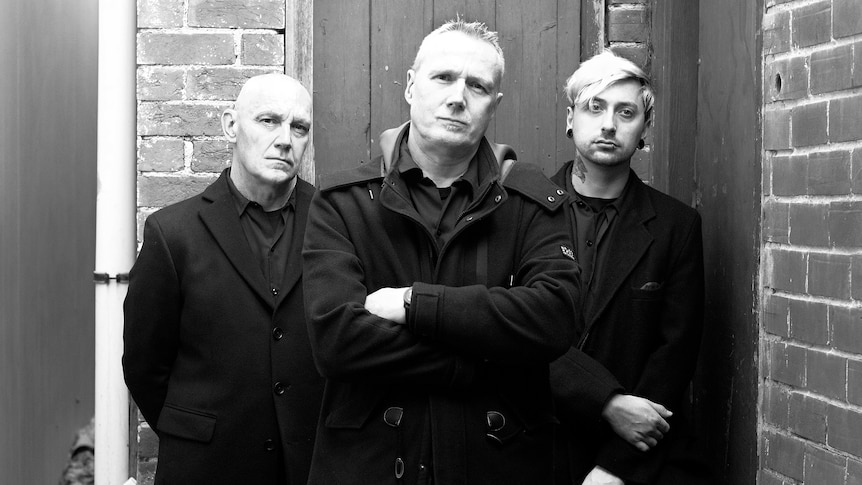 black and white photo of three members of rock band the mark of cain with arms folded