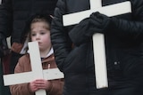 A young girl holds a crucifix as part of a march to commemorate victims of Bloody Sunday