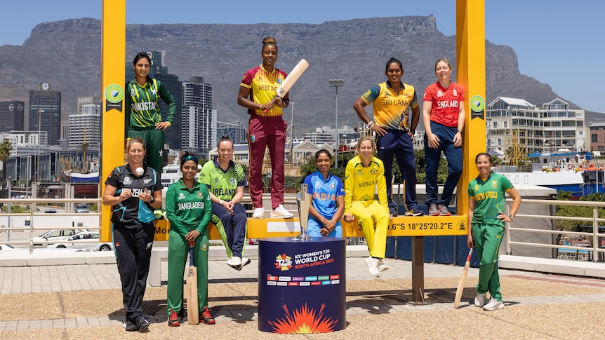 10 cricketers pose in their team gear in Cape Town with Table Mountain in the background to promote the Women's T20 World Cup.