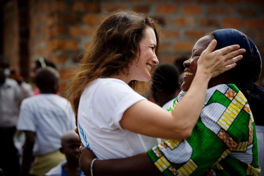 Actress and humanitarian Kristin Davis embraces a woman.