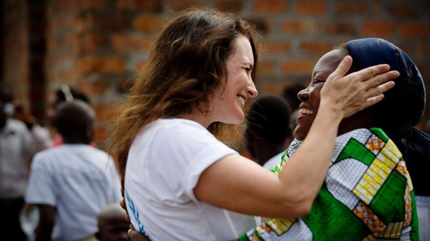 Actress and humanitarian Kristin Davis embraces a woman.