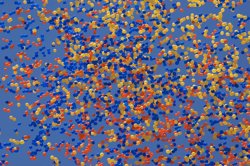 Thousands of colourful balloons floating away into the sky