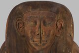 A carved face on the lid of the coffin