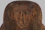 A carved face on the lid of the coffin