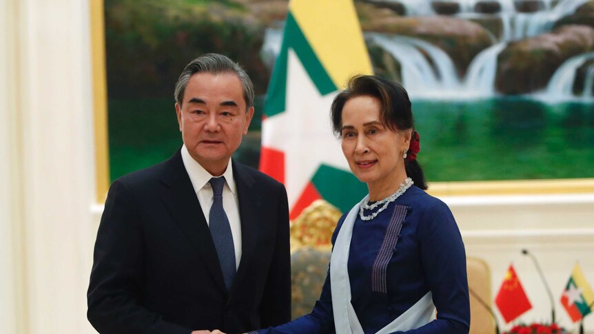 Myanmar's leader Aung San Suu Kyi, right, shakes hands with Chinese Foreign Minister Wang Yi, left.