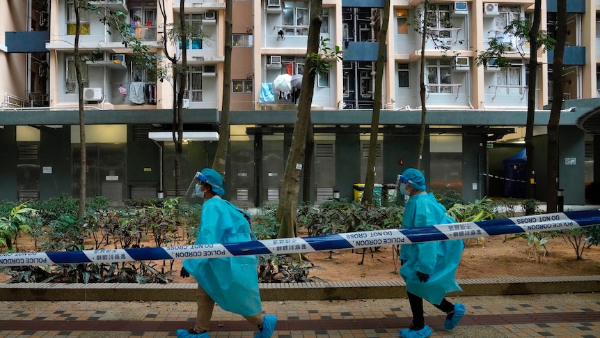 Health workers in protective gear walk at the lockdown area in Kwai Chung Estate.