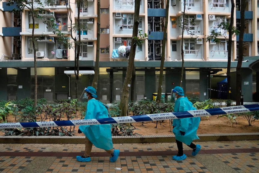 穿着防护装备的卫生工作者在葵涌邨的封锁区行走。