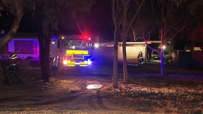 A fire truck in front of a shed at night