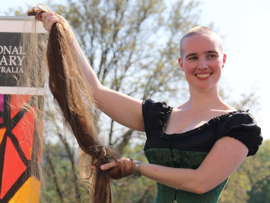 Ms Suttor displays her new shaved hairstyle and the recovered hair which will be used to make wigs.