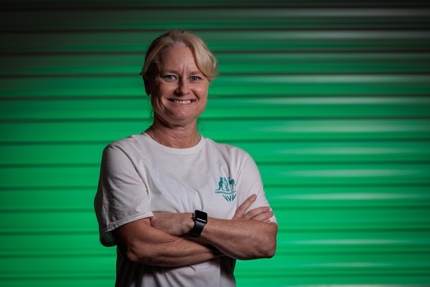 Katrina Powell stands with her arms folded, smiling at the camera