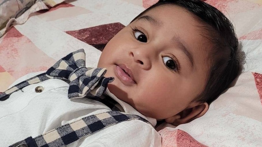 A baby boy, wearing a bow tie.