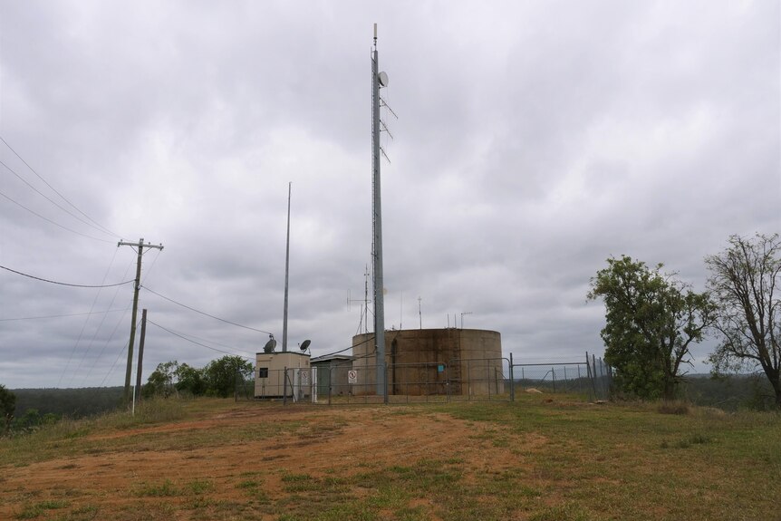 A transmission tower with fencing and other infrastructure around it