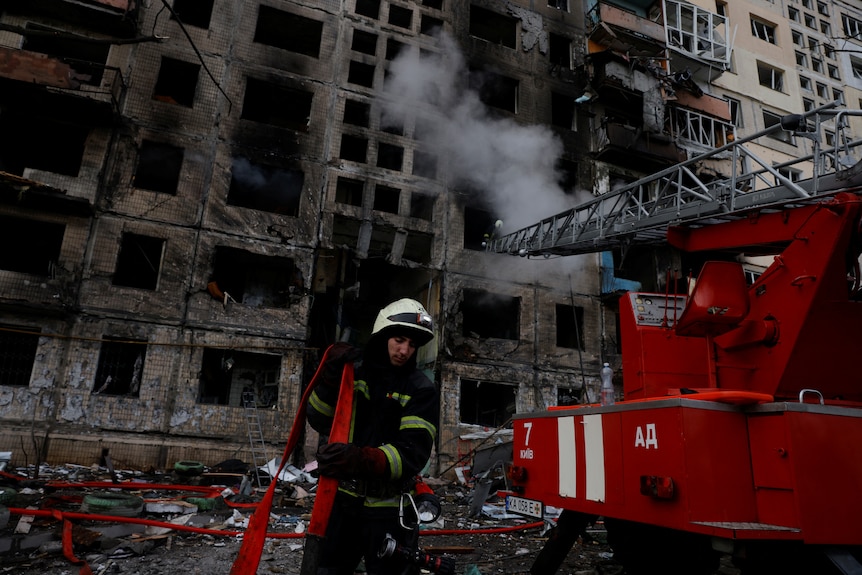 A firefighter exists a burnt out building. 