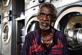 A man sits in front of washing machines in Barunga. 