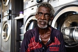 A man sits in front of washing machines in Barunga. 