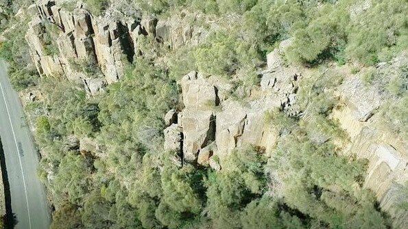 An aerial view of a rock wall near a road