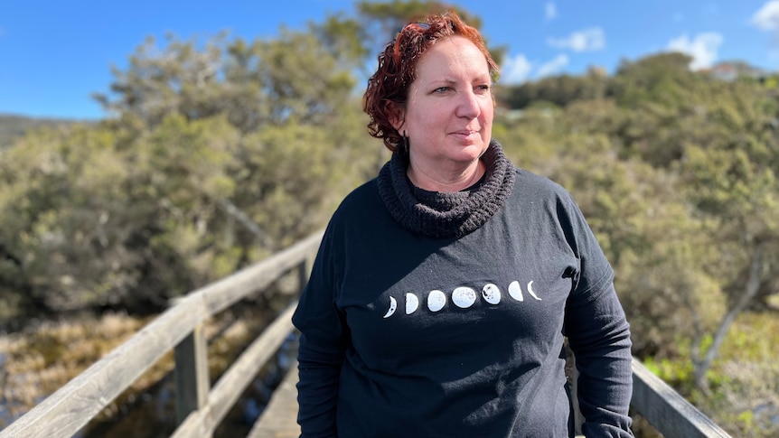 woman stands near a lake