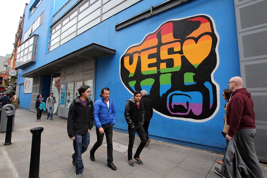 Voters walk past Vote Yes sign in Dublin ahead of the Referendum on same sex marriage.