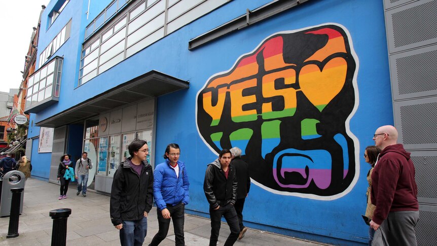 Voters walk past Vote Yes sign in Dublin ahead of the Referendum on same sex marriage.