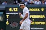 Roger Federer pumps his right fist while looking at the ground at Wimbledon.