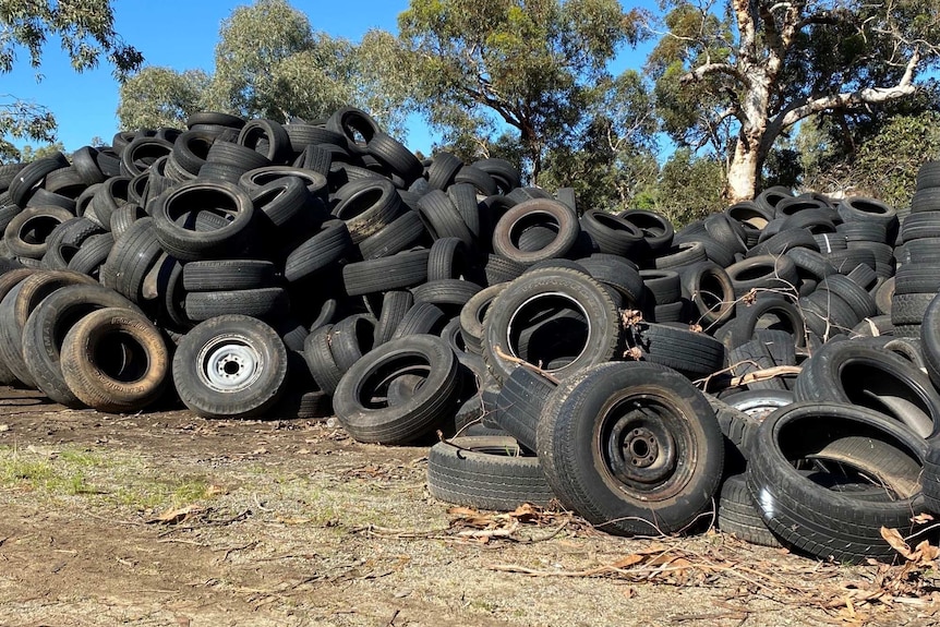 A pile of old tyres on a vacant land lot.