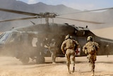 Australian Sergeant Medic Bernadette Serong escorts a casualty to a US Aero Medical Evacuation helicopter