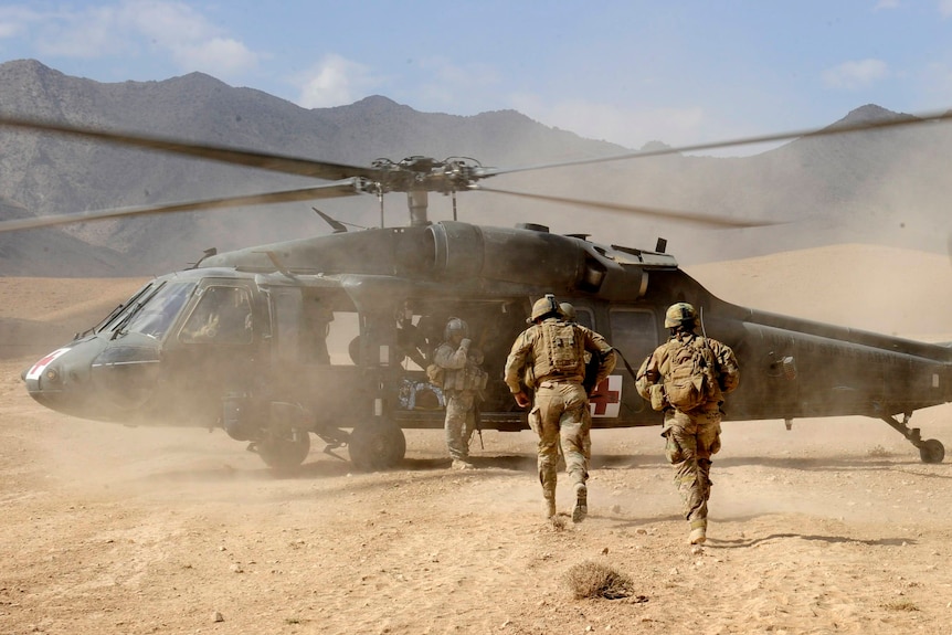 Australian Sergeant Medic Bernadette Serong escorts a casualty to a US Aero Medical Evacuation helicopter