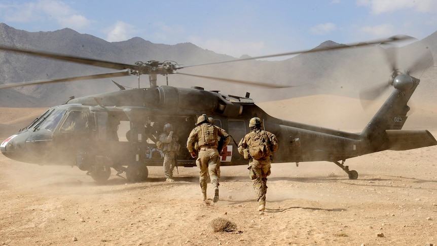 Australian Sergeant Medic Bernadette Serong escorts a casualty to a US Aero Medical Evacuation helicopter