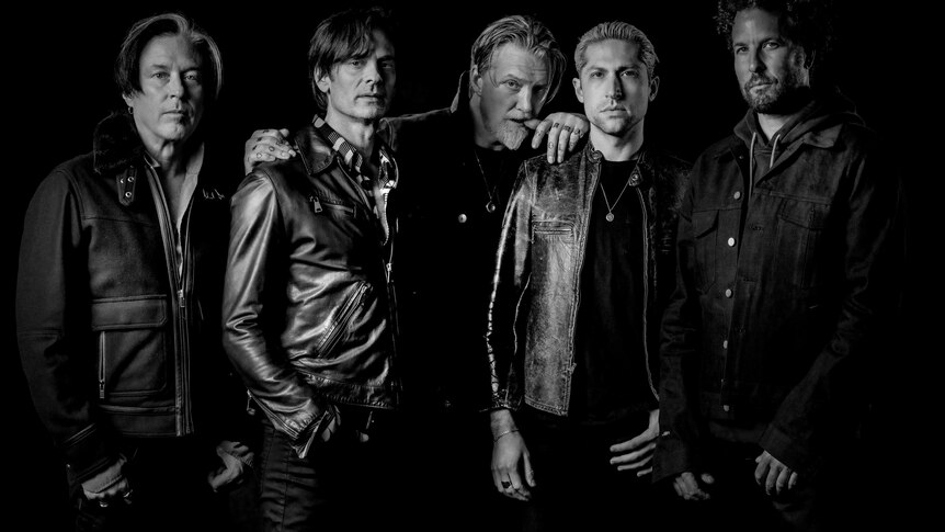 A black and white portrait of rock band Queens Of The Stone Age
