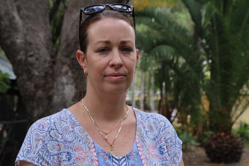 Kirsty French stands in a garden with trees in the background.