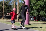 Nigel Cameron helps Mevaeh Sines skateboard