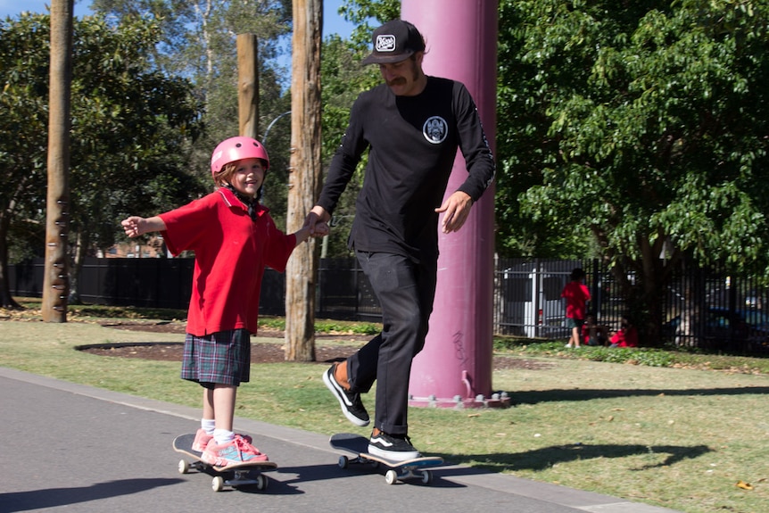 Nigel Cameron helps Mevaeh Sines skateboard