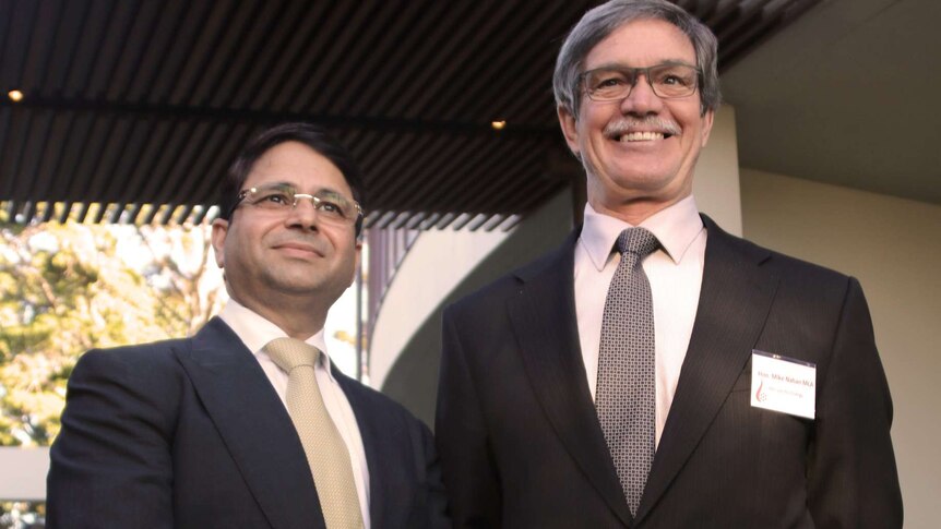 Vikas Rambal and Mike Nahan stand side by side posing for a picture outside a restaurant.