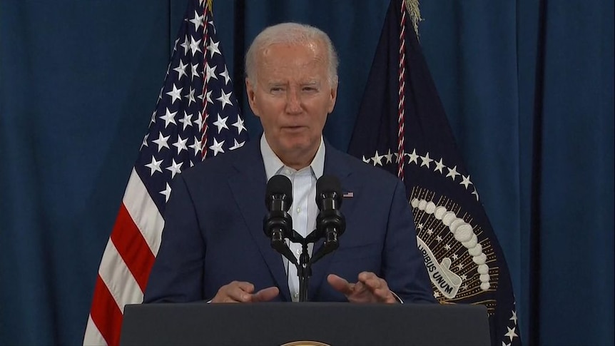 Joe Biden speaking into microphones at a lecturn.