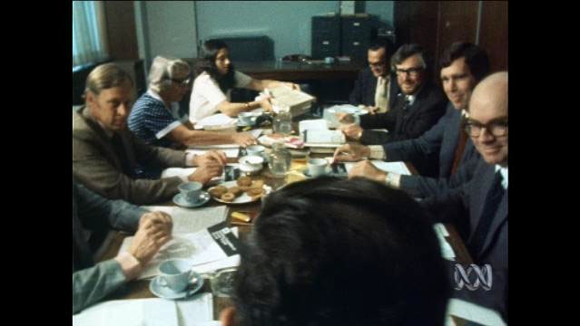 People sit around table in meeting