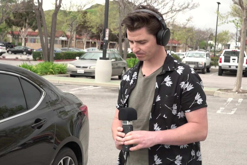 A man in a floral shirt preparing to conduct an interview.