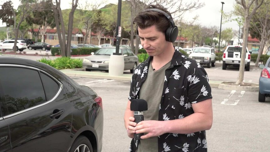 A man in a floral shirt preparing to conduct an interview.