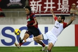 Shinzo Koroki evades a tackle by Sasa Ognenovski