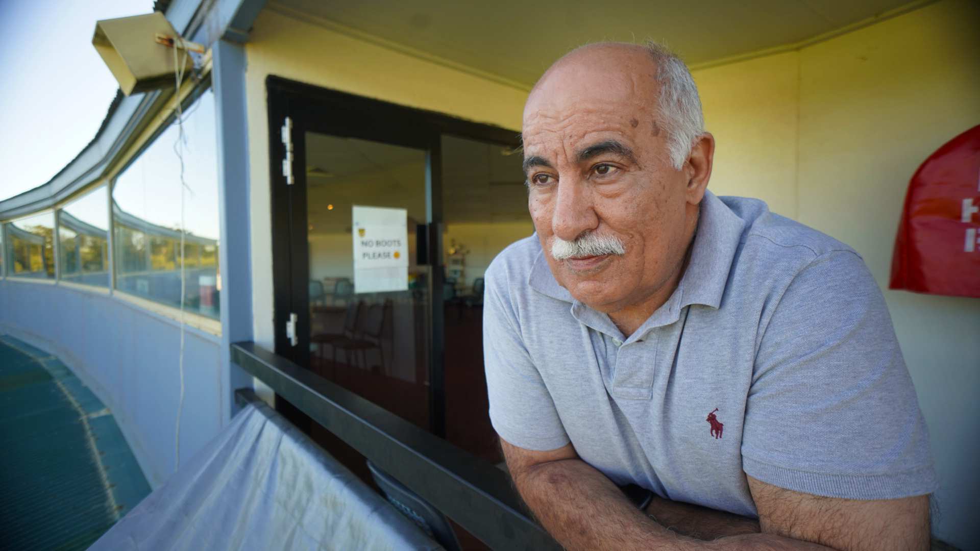 An older man looks out over a stadium.