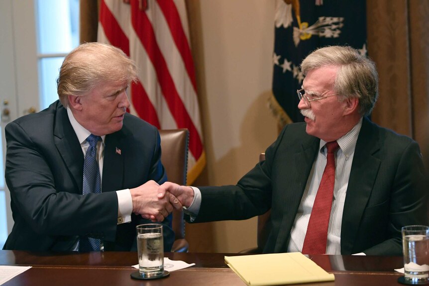 Donald Trump, left, shakes hands with John Bolton.