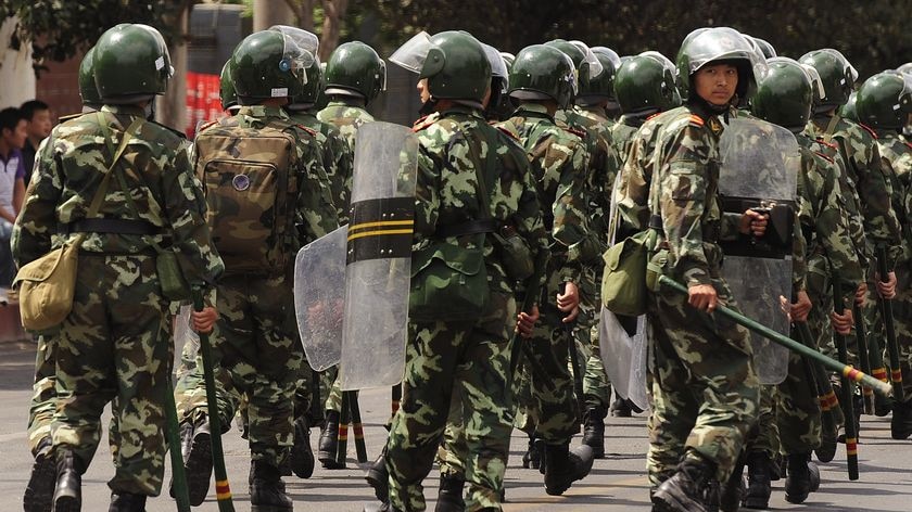 Chinese riot police patrol a street in Urumqi, Xinjiang