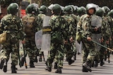 Chinese riot police patrol a street in Urumqi
