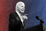 Joe Biden in black and white against a red blue gradient speaking at a podiumj 